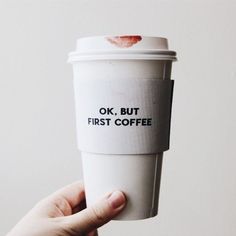 a person holding up a coffee cup with the words ok, but first coffee on it