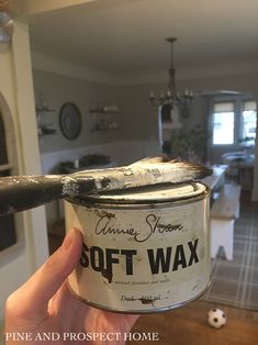 someone holding up a can of soft wax