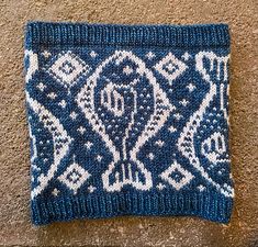 a blue and white knitted pouch sitting on the ground