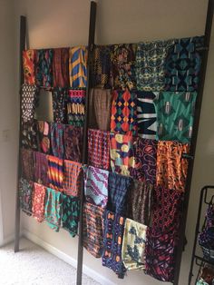 a rack full of colorful scarves hanging on the wall in front of a window