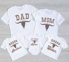 three shirts with the words dad, mom and baby in brown letters on them are sitting next to each other