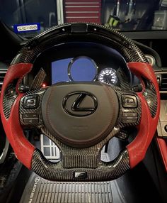 the interior of a car with red leather steering wheel covers