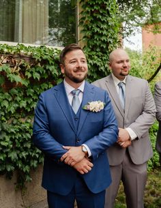 two men in suits standing next to each other