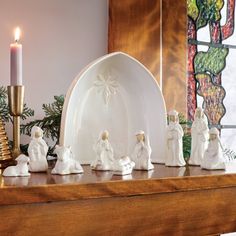 a group of figurines sitting on top of a table next to a candle