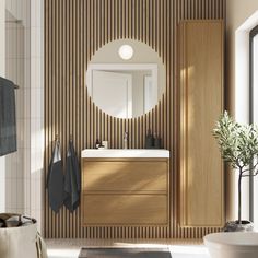 a bathroom with a sink, mirror and bathtub next to a plant in a vase