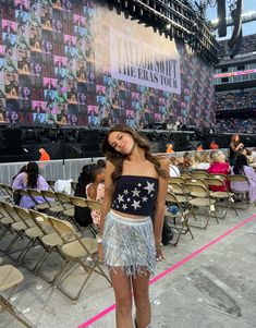 a woman standing on top of a stage next to chairs