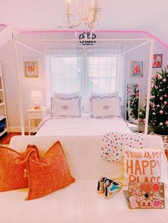 a white bed sitting in a bedroom next to a christmas tree