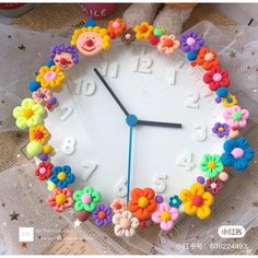 a clock made out of plastic flowers on a table