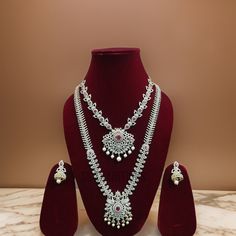 This stunning emerald AD necklace set is a must-have accessory for Indian brides. The exquisite design features sparkling CZ imitations of diamonds, adding elegance and sophistication to any bridal look. Perfect for traditional weddings and other special events, this necklace set is sure to turn heads and make a lasting impression. Earring Closure: pushback. All International Shipments of our Jewelry is dispatched through either FedEx or DHL and are delivered to your doorstep. Note: The product may be a slightly different shade from the picture because of picture editing. Please ask all questions regarding the color, size, measurements, etc before you buy Silver Wedding Sets With Elegant Design, Traditional Diamond White Jewelry Sets For Wedding, Traditional Crystal Bridal Sets For Celebration, Silver Diamond Sets As Gift, Silver Temple Jewelry Bridal Sets For Reception, Traditional Crystal Bridal Sets, Temple Jewelry Sets In Silver For Reception, Silver Temple Jewelry Sets For Reception, Traditional Multi-stone Bridal Necklace For Festive Occasion