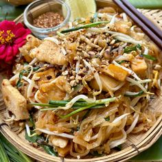 a plate filled with noodles and vegetables next to chopsticks