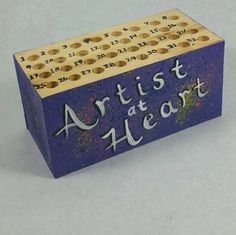 a wooden block with the words artist at heart written on it