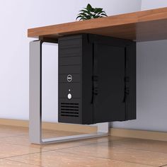 a computer tower sitting on top of a wooden desk next to a potted plant