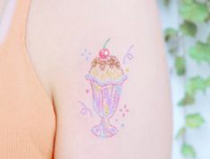 a woman with a tattoo on her arm has an ice cream sundae in it