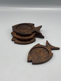 three wooden fish shaped coasters sitting on top of a table