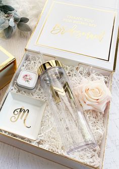 an open gift box with personal items in it on a white tableclothed surface