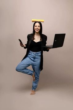 a woman is holding a laptop with a banana on top of her head while standing in the air