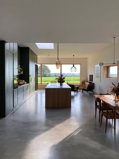 a large open kitchen and dining room with lots of natural light coming in from the windows