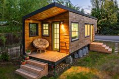 two tiny houses in the woods, one is made out of shipping containers and the other has