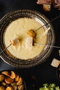 a bowl filled with cheese and crackers on top of a table next to other foods