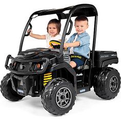 two children riding on the back of a black utility vehicle