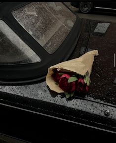 a bouquet of flowers sitting on the hood of a car