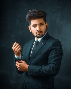 a man in a suit and tie is holding his hands together while wearing a watch