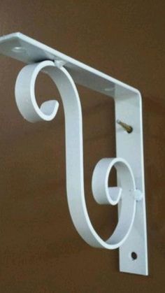 a close up of a white metal object on a brown wall with a light fixture in the background