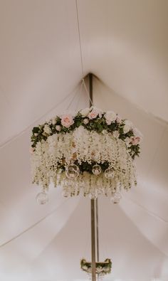 the chandelier is adorned with white flowers and greenery