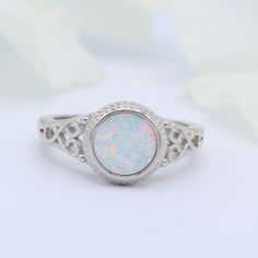 a white opalite ring with filigrees on it