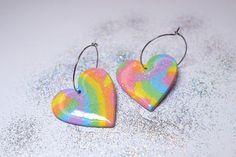 Celebrate love glitter and rainbows with these earrings! These hoop earrings are handcrafted from polymer clay and coated with a shiny layer of resin. The earrings are super lightweight. The hoops are stainless steel. hoops diameter: 2,5cm length: 4cm width: 3,5cm  These earrings make a great gift for everybody who likes fun and color! HOW TO TAKE CARE OF THE EARRINGS: Store them clean and dry. Clean them with a wet piece of cloth. Have in mind that the use of creams and oils may affect the long Heart Hoop Earrings, Rainbow Heart, Pastel Rainbow, Heart Earrings, Jewelry Earrings Hoops, Polymer Clay, Glitter, Hoop Earrings, Pastel