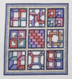 a cross stitched quilt with squares on it