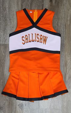 This listing is for Sallisaw Cheerleading costume, constructed of Orange  heavy weight double knit fabric, with white yoke  and black polyester knit braid. Shadow block Embroidery included. Top has a zipper back and skirt has elastic waist. Bloomers are not included.  Machine wash and dry.   Runs true to size, order regular ready made size. You may send measurements in personalization box if unsure of exact size needed. Constructed in a smoke free and pet free home. Fitted White School Costume, White Fitted School Costume, Fitted White Costume Sets, White Cotton Cheerleading Sets, White Cotton School Spirit Sets, Fitted Cotton Cheerleading Sets, Cheerleading Costume, Girls Costumes, Double Knit