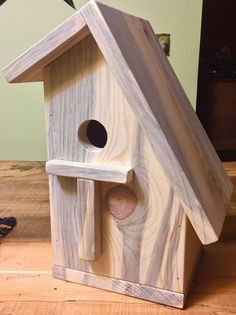 a birdhouse made out of wood with a star on the wall in the background