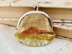 a small purse sitting on top of a book