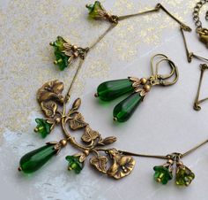 "VINTAGE ELEMENTS Unique Jewellery, Handmade from Vintage Inspired Original Designs Ethereal, Art Nouveau Style, antiqued brass Necklace and Earring set with Emerald Green, Czech glass drops, and Czech glass Bell Flower beads in corresponding tones. The Necklace, made with antiqued brass bar chain measures 17\" (43cm)   in length plus a 3\" (8cm) extender chain. The earrings have antiqued brass leverback earwires and matching  Emerald Green Teardrops. They measure 4.9cm from the top of  the earw Bijoux Art Nouveau, Art Nouveau Antiques, Vintage Elements, Green Jewelry, Art Nouveau Jewelry, Floral Necklace, Emerald Jewelry, Fantasy Jewelry, Jewelry Inspo