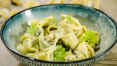 a close up of a bowl of food with broccoli and noodles in it