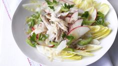 a white plate topped with lettuce, radishes and other food items