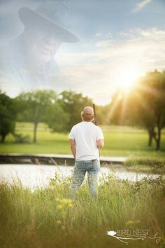 a man is standing in the grass with his back to the camera and looking at something