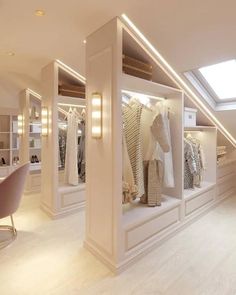 a room filled with lots of white furniture and shelves full of clothes on hangers