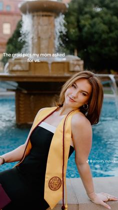 a woman sitting on the ground next to a fountain wearing a yellow and black tie