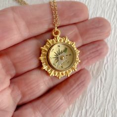 Introducing our captivating Gold Working Compass Necklace - a fusion of style and functionality that's bound to delight the hearts of avid hikers and travelers alike. This unique piece showcases a working magnetic compass elegantly encased within a radiant gold-plated brass bezel, creating a truly unique and thoughtful gift. At 24mm in width, the bright gold setting is roughly the size of a quarter coin, making it a striking centerpiece that catches the eye. The compass itself is crafted from hi Gold Compass Necklace, Magnetic Compass, Compass Jewelry, Compass Pendant, The Compass, Compass Necklace, Jewelry Lookbook, Bright Gold, Travel Jewelry