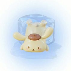 a plastic toy dog laying on its back in front of an ice block that is shaped like it's head