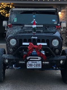 the jeep is decorated for christmas with red bows