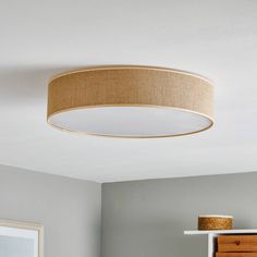 a light that is hanging from the ceiling in a room with white walls and furniture