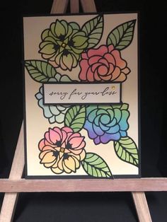 an easel holding a card with flowers on it