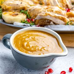 a bowl of soup next to a platter of food