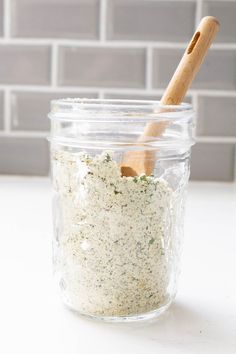 a glass jar filled with white stuff and a wooden spoon in the top right corner