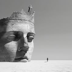 a person standing next to a large statue in the middle of a field with a sky background