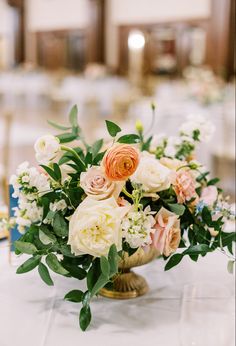 a vase filled with white and pink flowers on top of a marble tablecloth covered floor