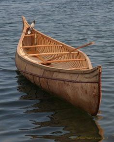 a canoe with two oars sitting in the water